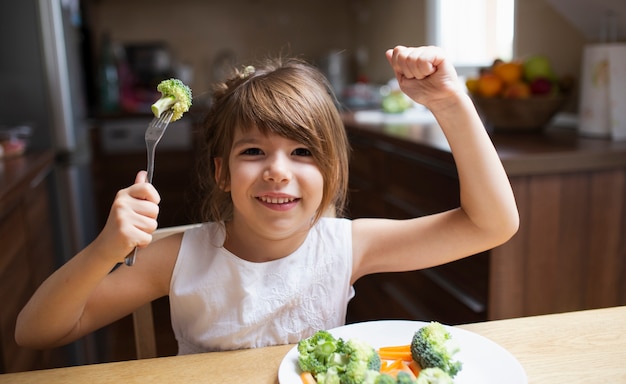 Free photo smiley girl playing with food