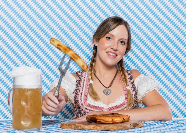 Free photo smiley girl presenting bavarian sausages