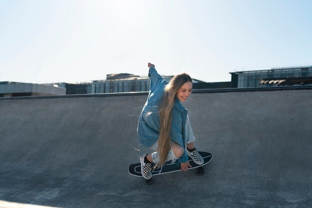 Smiley girl on skateboard outdoors side view