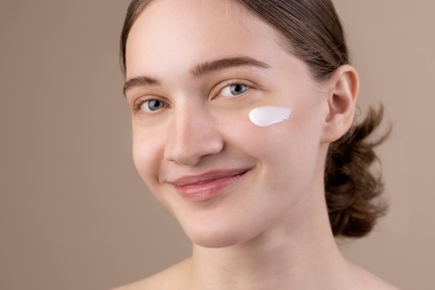 Smiley girl using eye cream side view