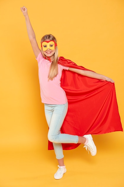 Free photo smiley girl wearing superhero costume