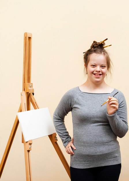 Smiley girl with down syndrome posing with brush