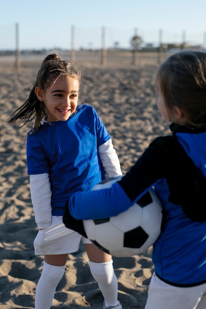 Free photo smiley girls with football at beach