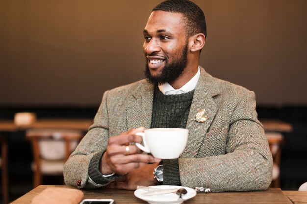 Smiley handsome man holding a cup with coffee