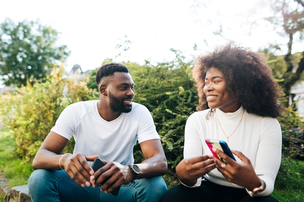 Smiley intercultural friends sitting on bench