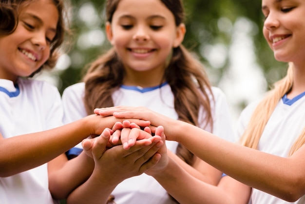 Smiley kids putting their hands on each other