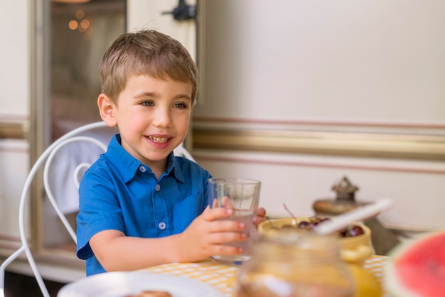 Smiley little boy holding a glass of lemonade