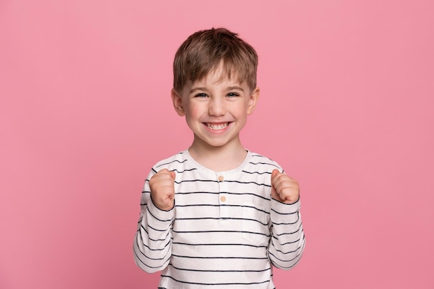 Smiley little boy isolated on pink