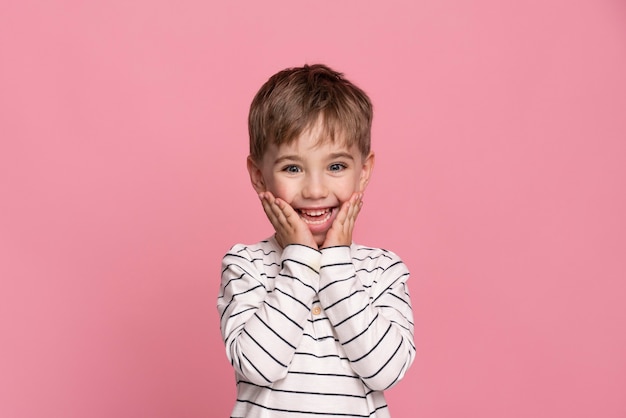 Smiley little boy isolated on pink