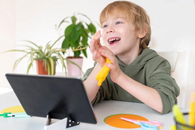 Smiley little boy using tablet at home