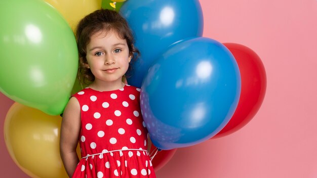 Smiley little girl in a red dress celebrating her birthday