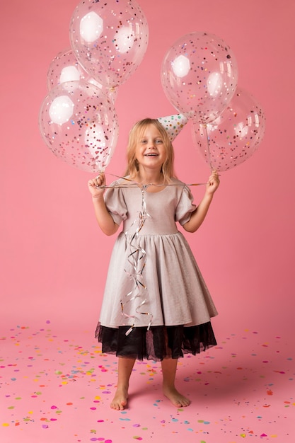 Smiley little girl with balloons in costume