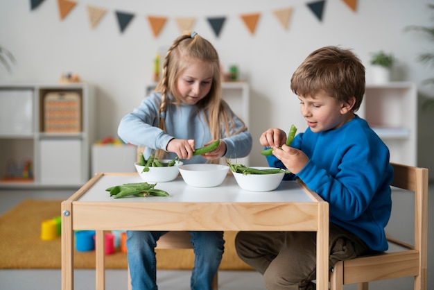 Free photo smiley little kids with green beans