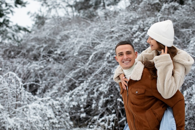 Smiley man carrying girlfriend medium shot