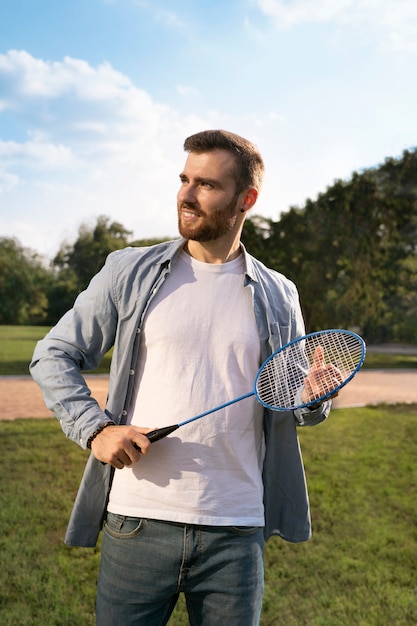 Smiley man holding racket front view