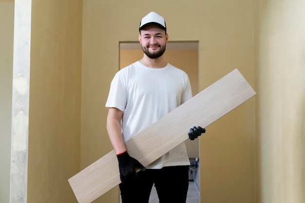 Smiley man holding tile medium shot