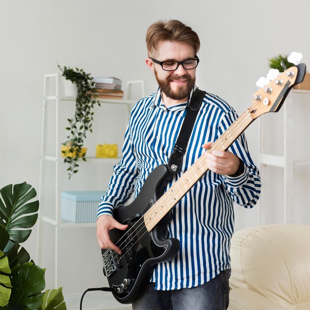 Smiley man at home with electric guitar