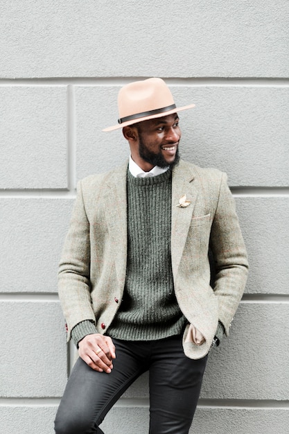 Smiley man posing on a grey wall