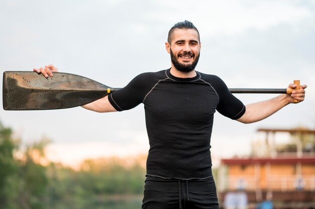 Smiley man posing with oar