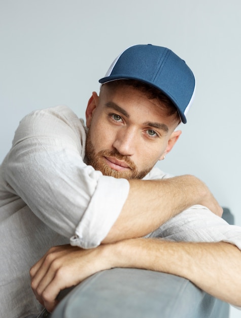 Free photo smiley man posing with trucker hat medium shot