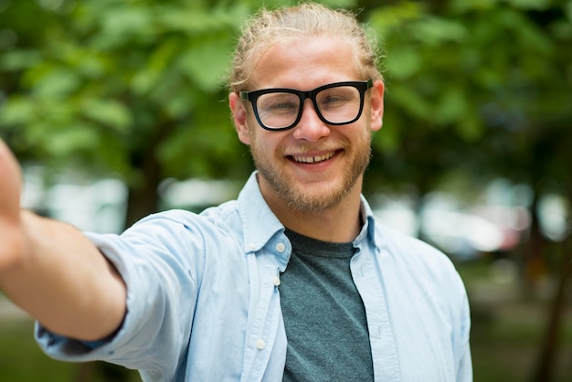 Free photo smiley man reaching his hand to pose