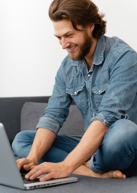 Smiley man typing on laptop's keyboard