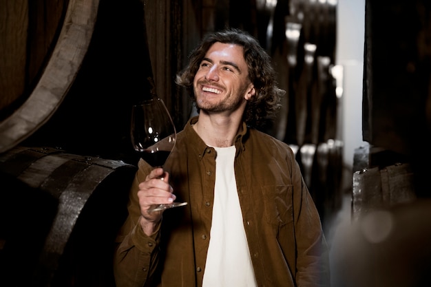 Free photo smiley man in wine cellar medium shot