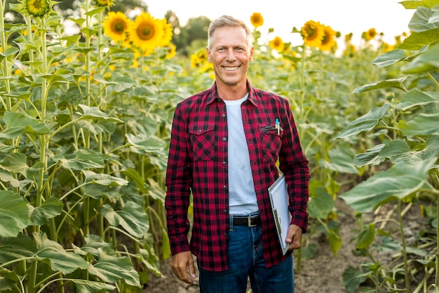 Smiley man with a clipboard in a field