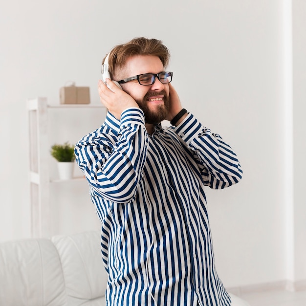 Free photo smiley man with headphones enjoying music