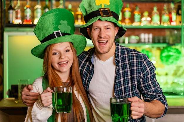 Free photo smiley man and woman celebrating st. patrick's day at the bar