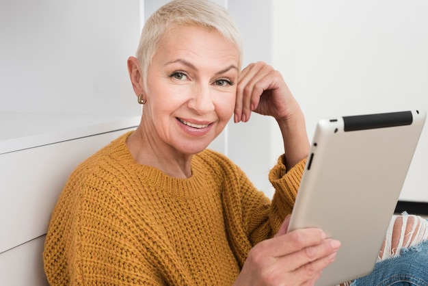 Free Photo smiley mature woman holding tablet