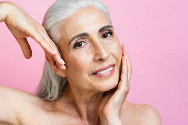 Free photo smiley mature woman with pink background