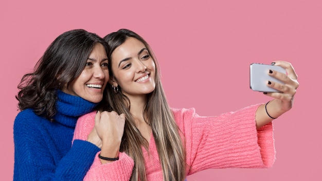 Free photo smiley mom and daughter taking selfie