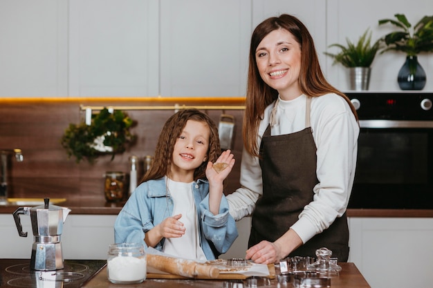 Smiley mother and daughter cooking together in the kitchen