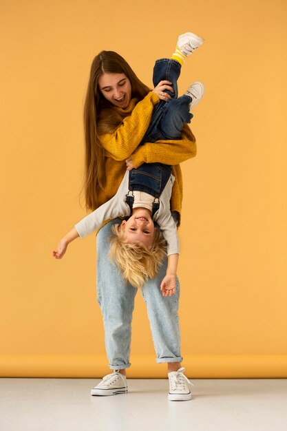 Smiley mother and kid in studio front view