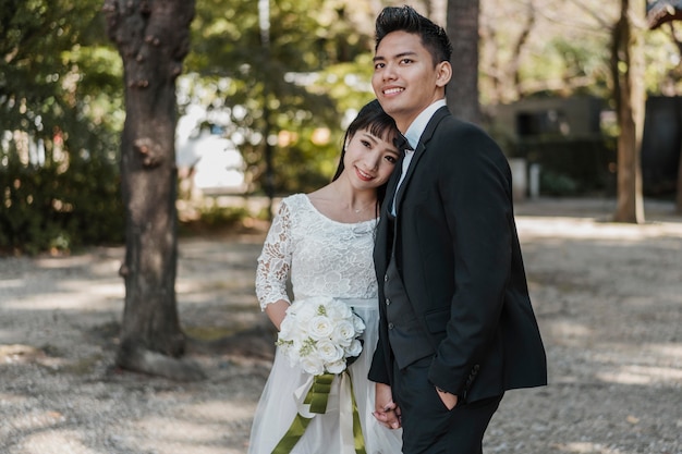 Smiley newlyweds posing together outdoors