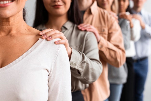 Smiley people touching shoulders at a group therapy session