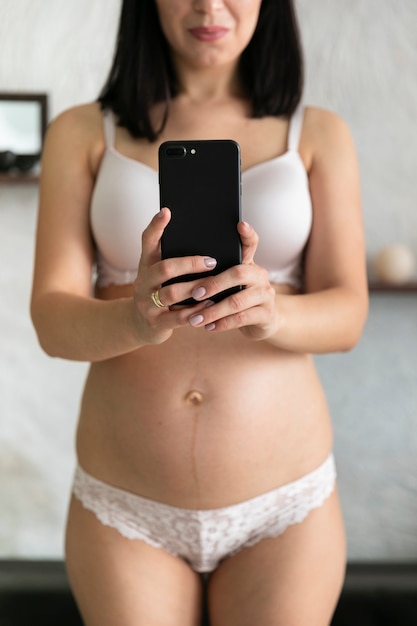 Smiley pregnant woman taking a selfie