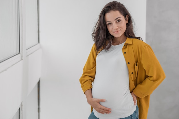 Free photo smiley pregnant woman with copy space