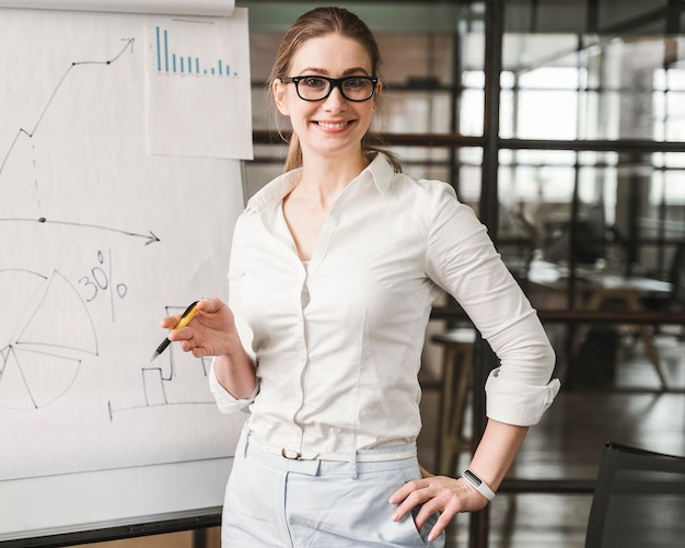 Free Photo smiley professional businesswoman with glasses giving a presentation