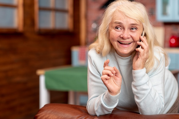 Free photo smiley senior talking over phone