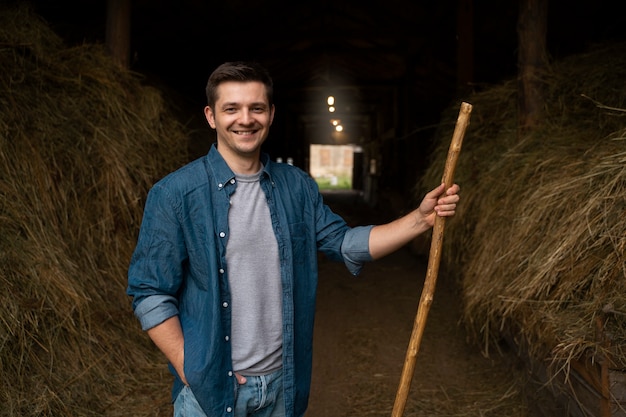 Free photo smiley shepherd with pitchfork medium shot