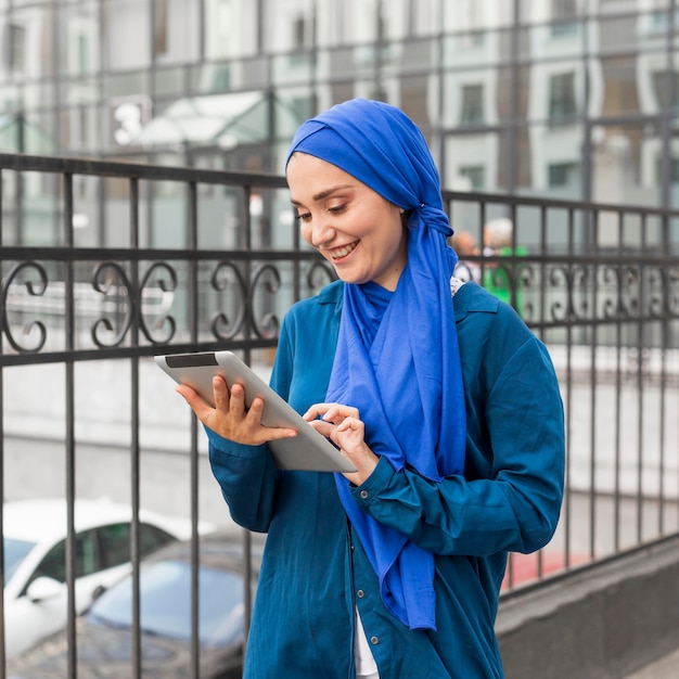 Smiley teenager looking on her tablet