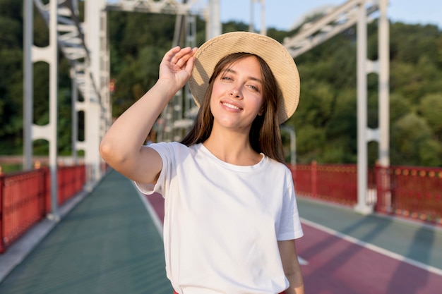 Smiley traveling woman on bridge with hat