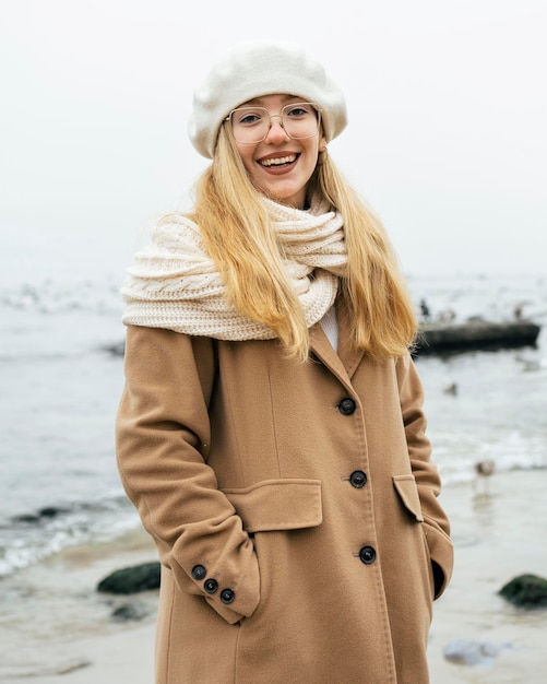 Free photo smiley woman at the beach in winter