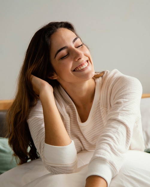 Smiley woman in bed at home