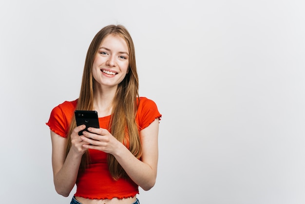 Smiley woman checking her phone with copy space