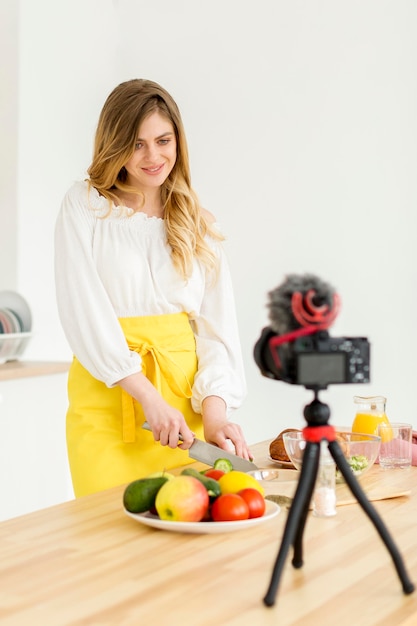 Free photo smiley woman cutting vegetables