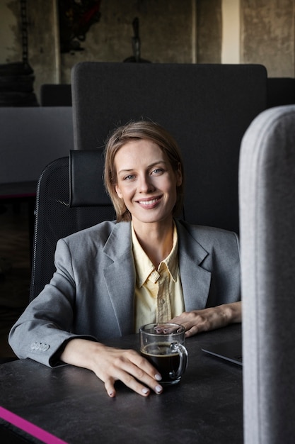 Free photo smiley woman at desk front view