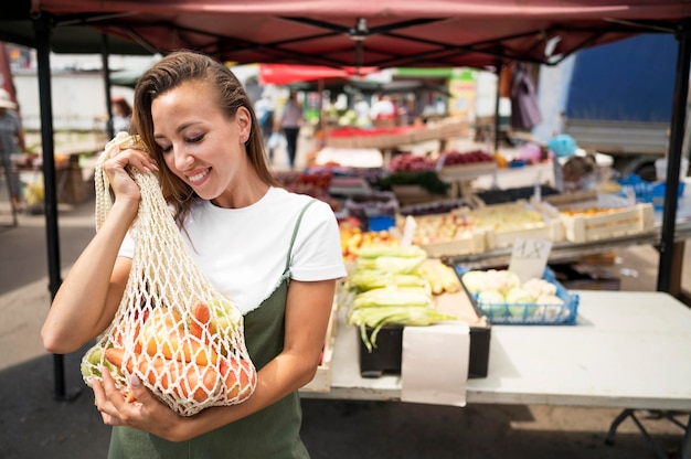 Smiley woman doing groceries shopping with copy space